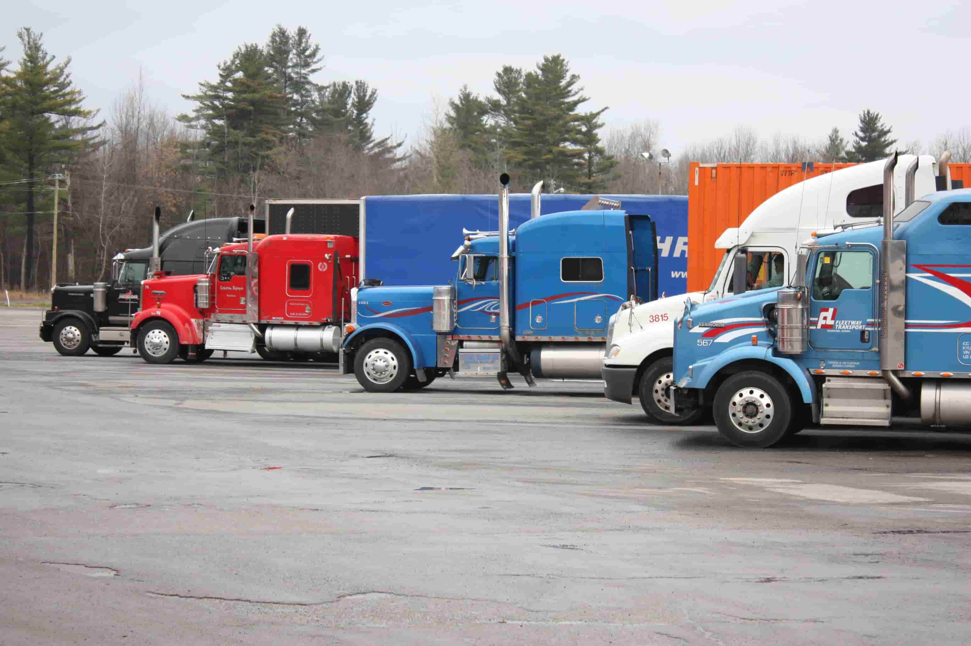 Commercial trucks staged at a freight yard, the kind of equipment Arlington, Texas owner-operators insure