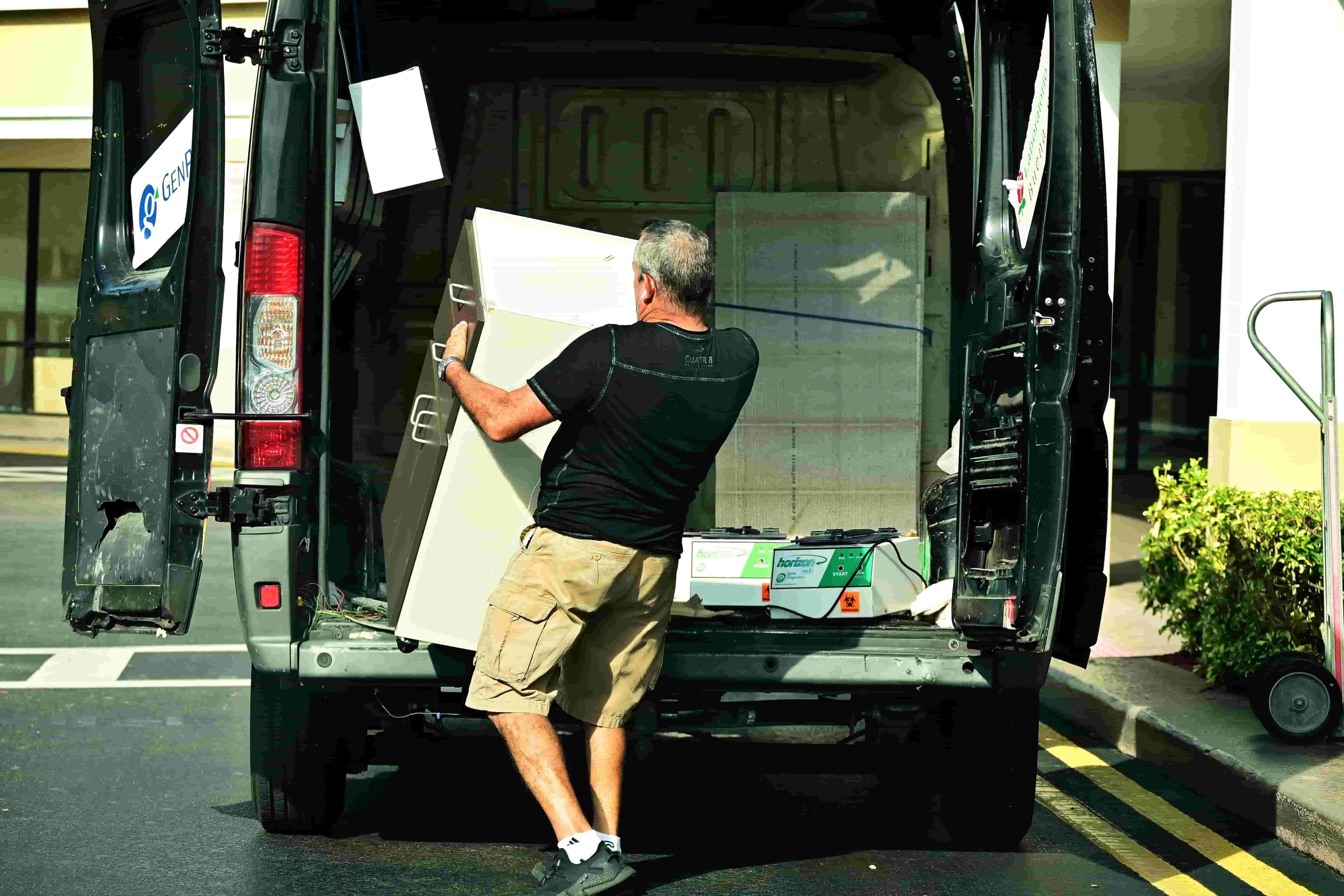 Worker loading equipment into the back of a cargo work van