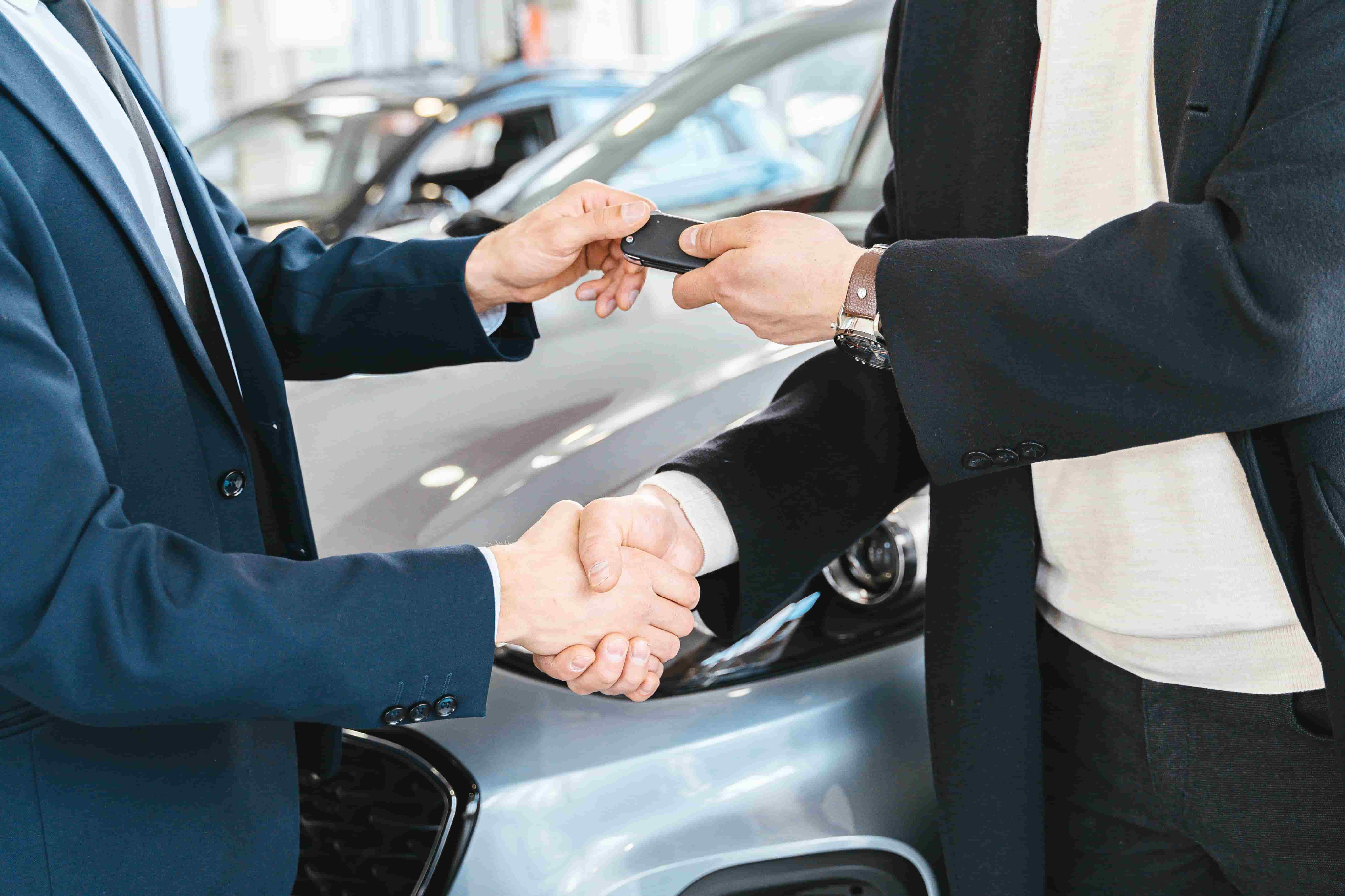 Parent handing car keys to a teenage driver, representing adding a teen driver to a car insurance policy